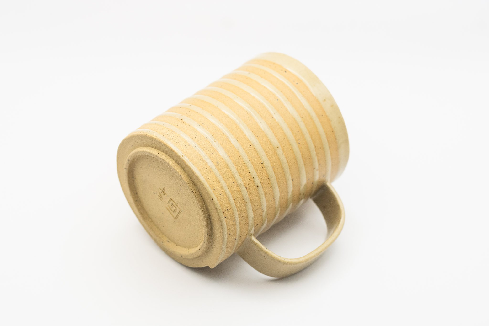 Tan handmade white spiral mug with handle