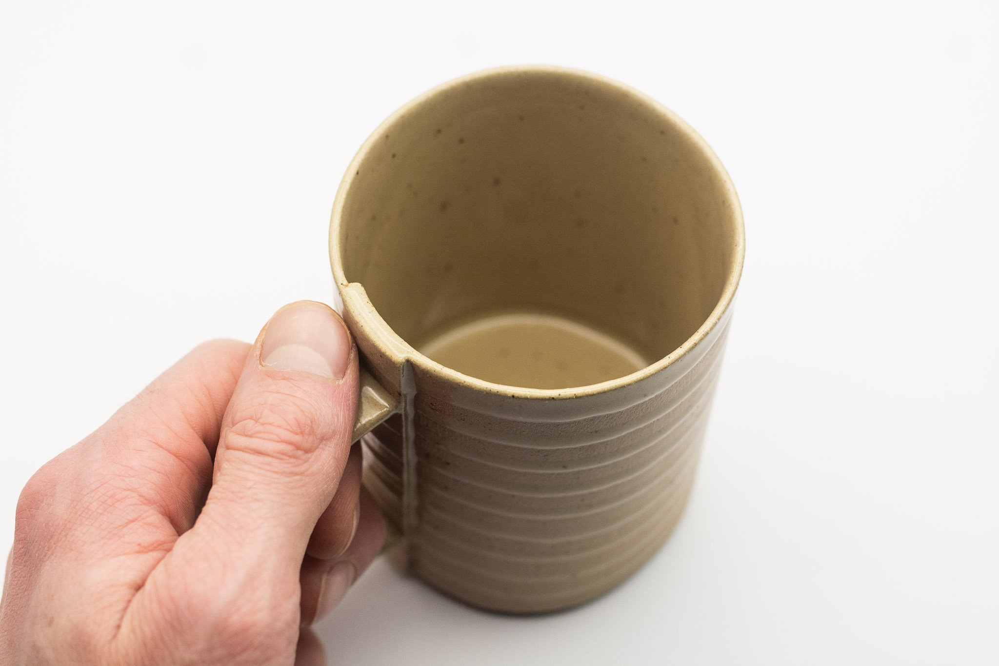 Tan handmade white spiral mug with handle